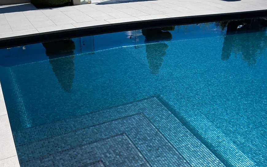A heated swimming pool with a tiled surround